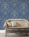 Navy blue and gold Afternoon Arbor damask wallpaper with ornate floral scrollwork behind tufted settee