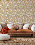 White wall covering featuring green and amber leaves on a botanical vine pattern (Amber Breeze)