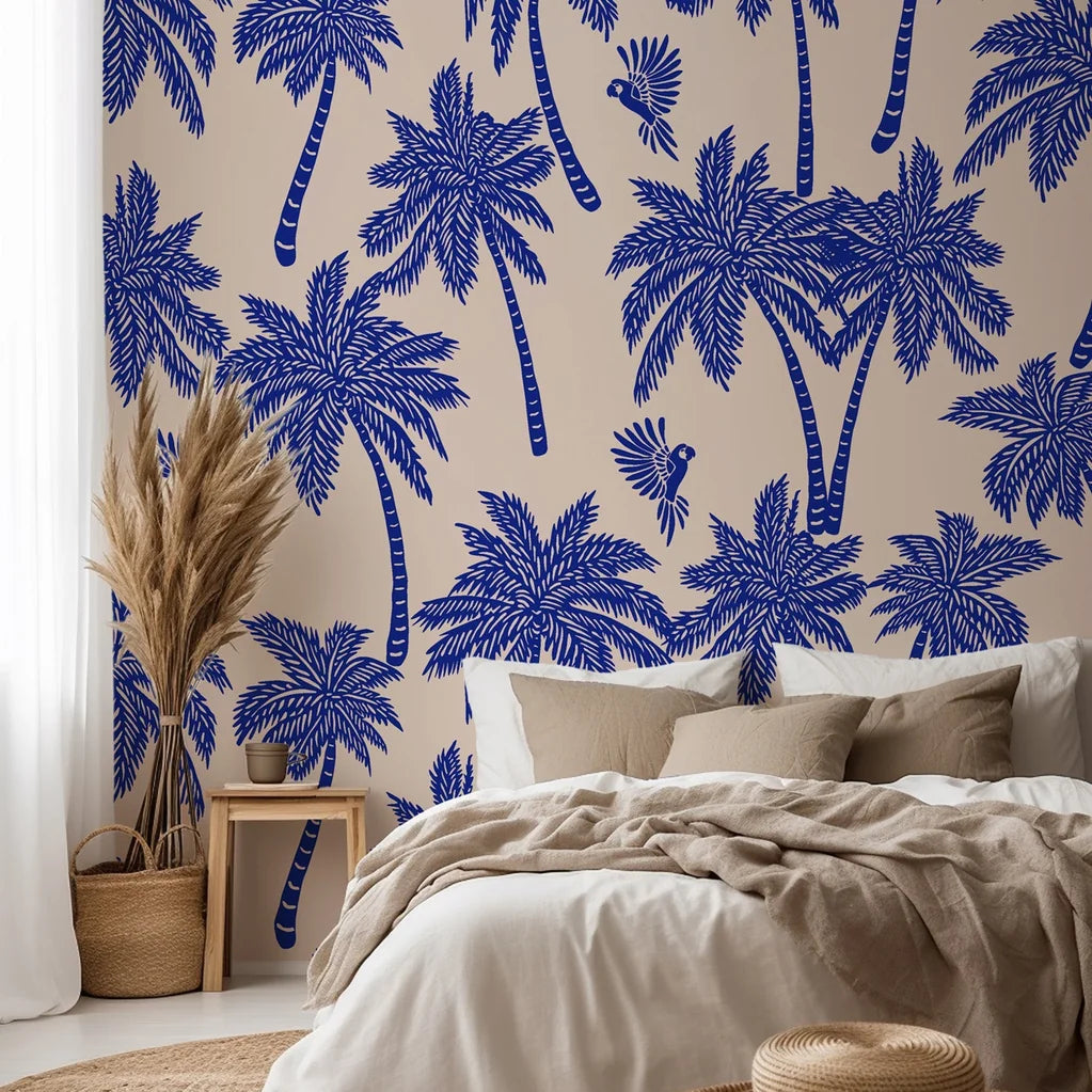 Tropical palm wallpaper featured on a bedroom wall, creating a relaxed coastal interior with bold blue palm silhouettes.