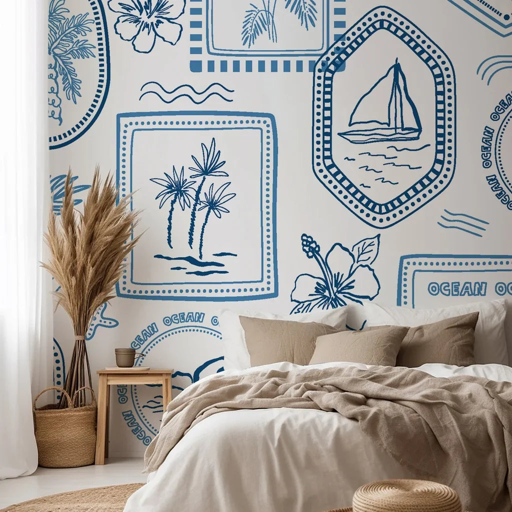 Nautical toile wallpaper installed in a bedroom, featuring sailboats, palm trees, and ocean icons that evoke a classic coastal atmosphere.
