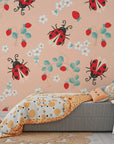 Self-adhesive peach-colored wallpaper showcasing a charming garden pattern of ladybirds and wild berries. - Berry Wings