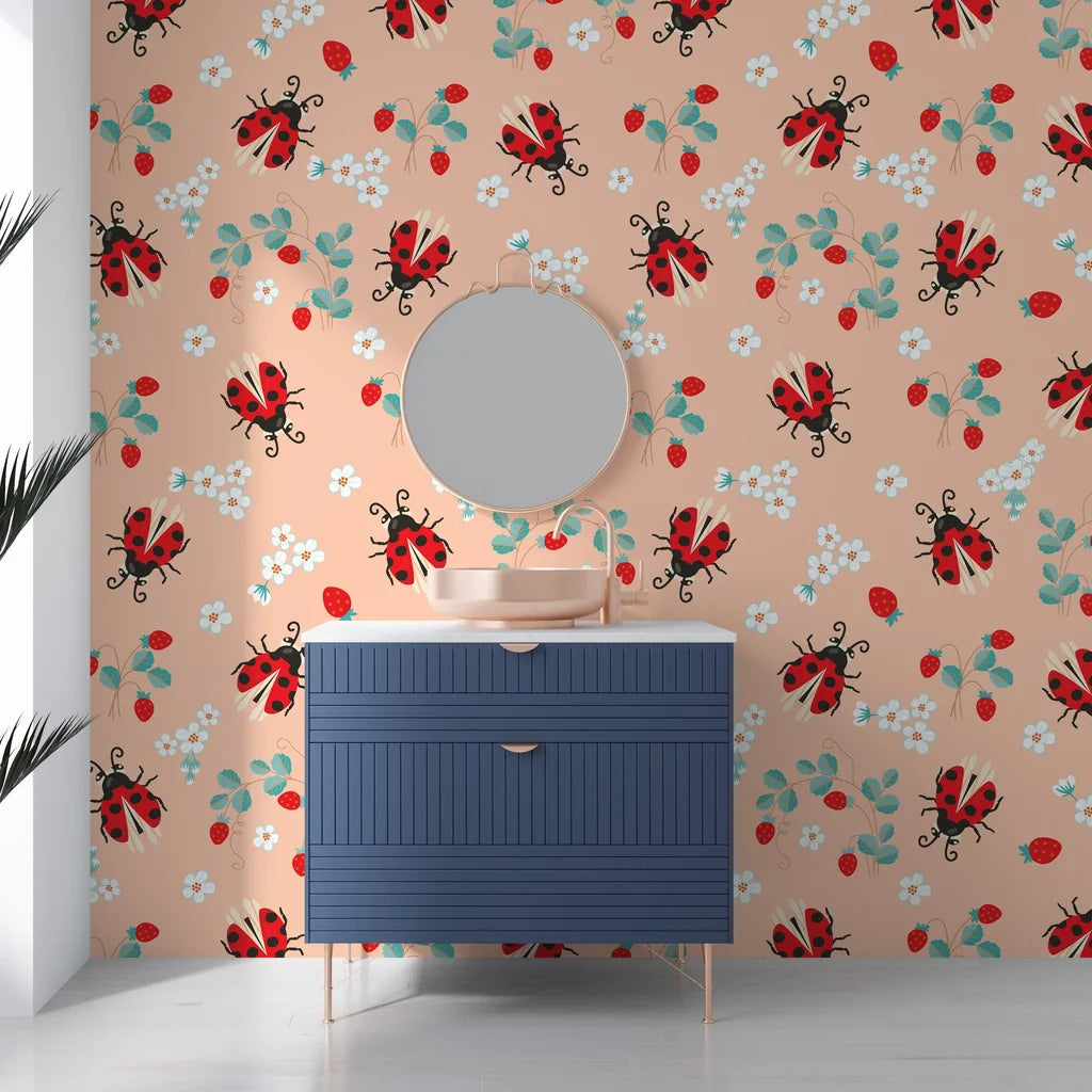 Minimalist peach backdrop adorned with detailed ladybug and strawberry illustrations on a removable vinyl surface. - Berry Wings