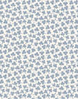 Soft porcelain blue floral wallpaper with small hand stamped blossoms scattered across a warm ivory background.