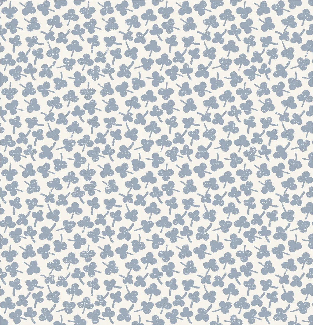 A warm ivory wall covering featuring a scattered pattern of delicate, pale porcelain blue, hand-printed flower motifs