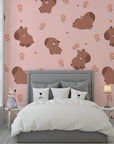 Adorable brown capybaras nestled among soft pink blossoms on a self-adhesive wall mural - Blush Blooms