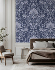 Vintage damask wallpaper with distressed ivory scrollwork and ornate floral motifs on a deep navy blue background.