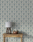 Highly detailed floral wallpaper in the Art Nouveau style, comprised of undulating dark teal scrollwork and clusters of soft ivory blossoms set against a porcelain cream field