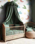 Whimsical nursery wallpaper with pastel moons, stars, clouds, leaves, and hearts scattered across a soft white background.