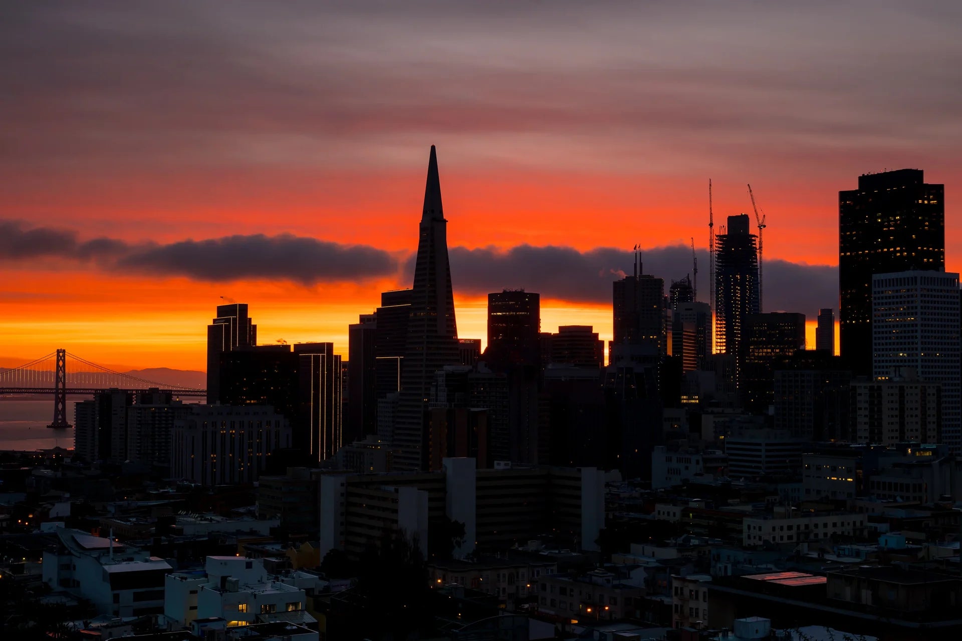 Dramatic Burning Horizon wallpaper featuring San Francisco skyline silhouette against vibrant orange and purple sunset sky