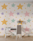 Soft-textured self-adhesive wall covering with a light beige backdrop featuring delicate pastel starbursts and celestial shapes. - Celestial Dream