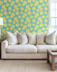 Against a plain white background, bright yellow lemons and green leaf sprigs drape horizontally.