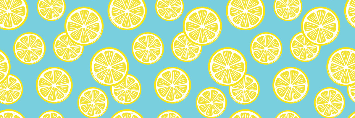 Greenery and vivid yellow citrus fruits are arranged flowing diagonally across the white space