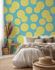 Vivid yellow lemons and verdant foliage flow over a white surface.