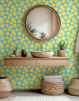 Green foliage and sunny yellow lemons are pictured trailing diagonally over a plain white surface.