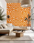 Self-adhesive wallpaper featuring an orange, mid-century geometric pattern of semicircles, known as the Citrus Grid design