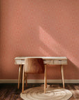 Coral geometric wallpaper with hand-drawn line patterns forming a soft, symmetrical abstract design.