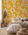 Whimsical ochre wallcovering featuring an off-white hand-drawn floral design—Cosmic Bloom