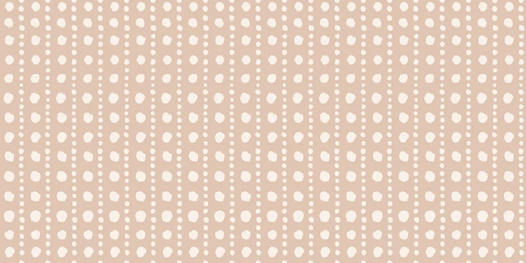 A wallpaper featuring a warm tan base adorned with soft white, hand-painted polka dots placed in a loose grid pattern