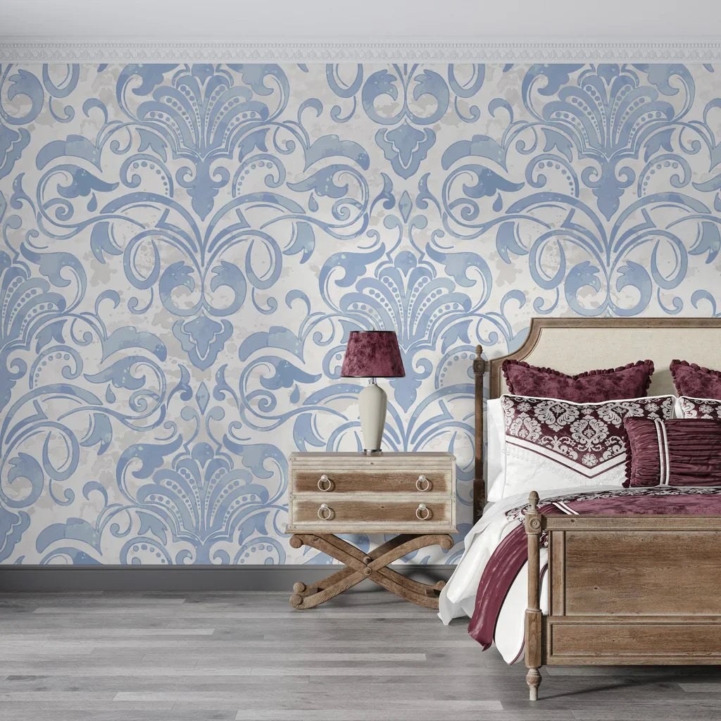 Blue and cream Dusky Garden Waltz damask wallpaper displayed on bedroom accent wall with ornate scrollwork pattern