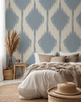 A warm, nearly-white backing supports a softly textured, patterned wallpaper, displaying light blue, repeating ikat diamonds