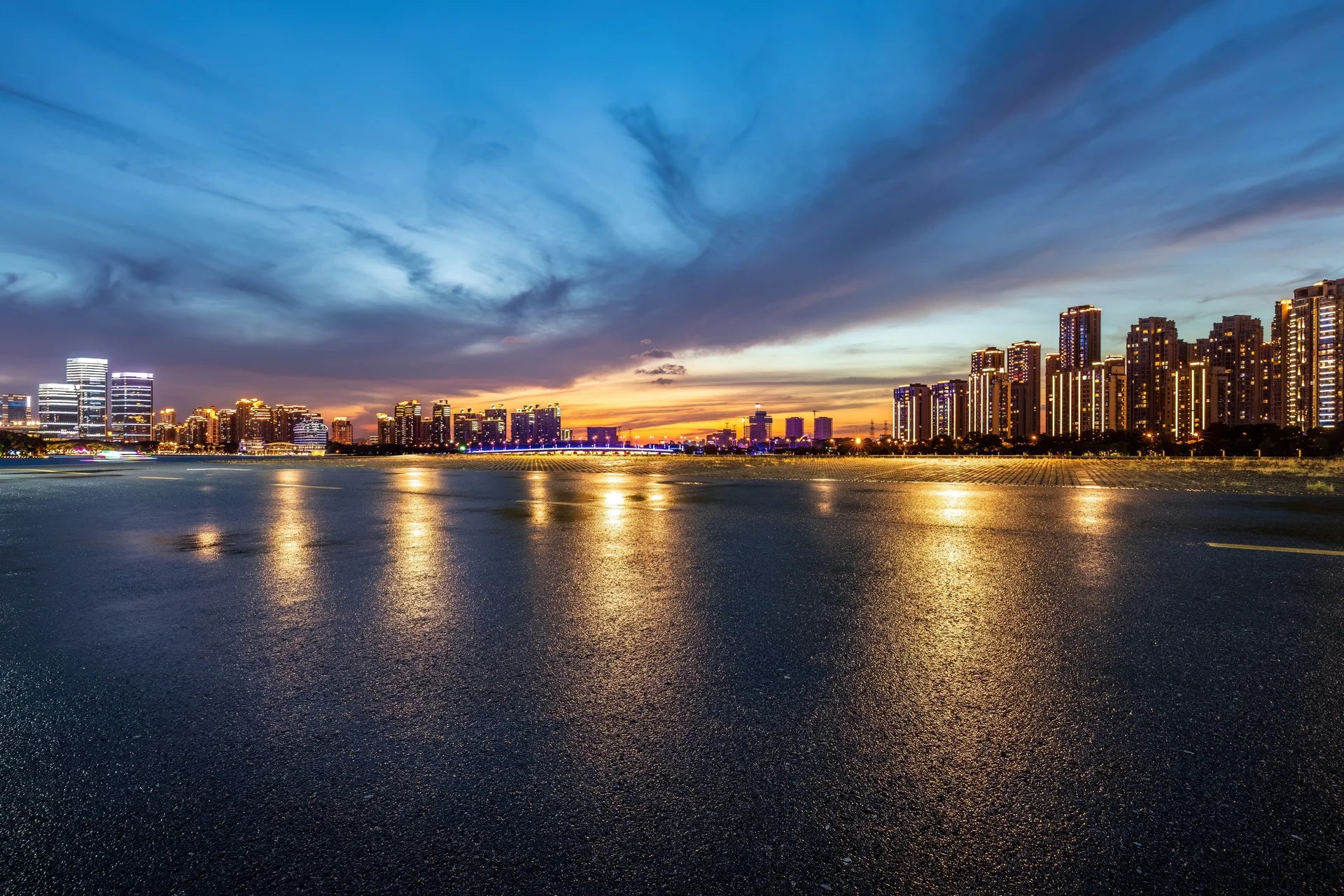 Dramatic sunset cityscape with blue and golden skies reflected on water, Embers On The Horizon wallpaper mural