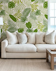 Removable wallpaper featuring a vibrant pattern of green monstera and palm leaves