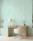 First Bloom aqua floral peel and stick wallpaper as a feature wall in a bright home office