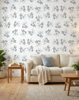Frost Berry botanical wallpaper with gray leaves and blue berries on cream background in modern living room