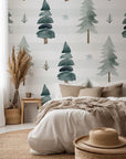 A self-adhesive wallpaper featuring a watercolor design of striped green pine trees, part of the Frosted Woods collection