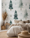 A self-adhesive wallpaper featuring a watercolor design of striped green pine trees, part of the Frosted Woods collection