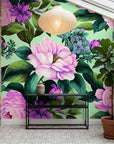 Full Bloom botanical wallpaper with pink peonies and purple flowers on mint green in modern sunlit room