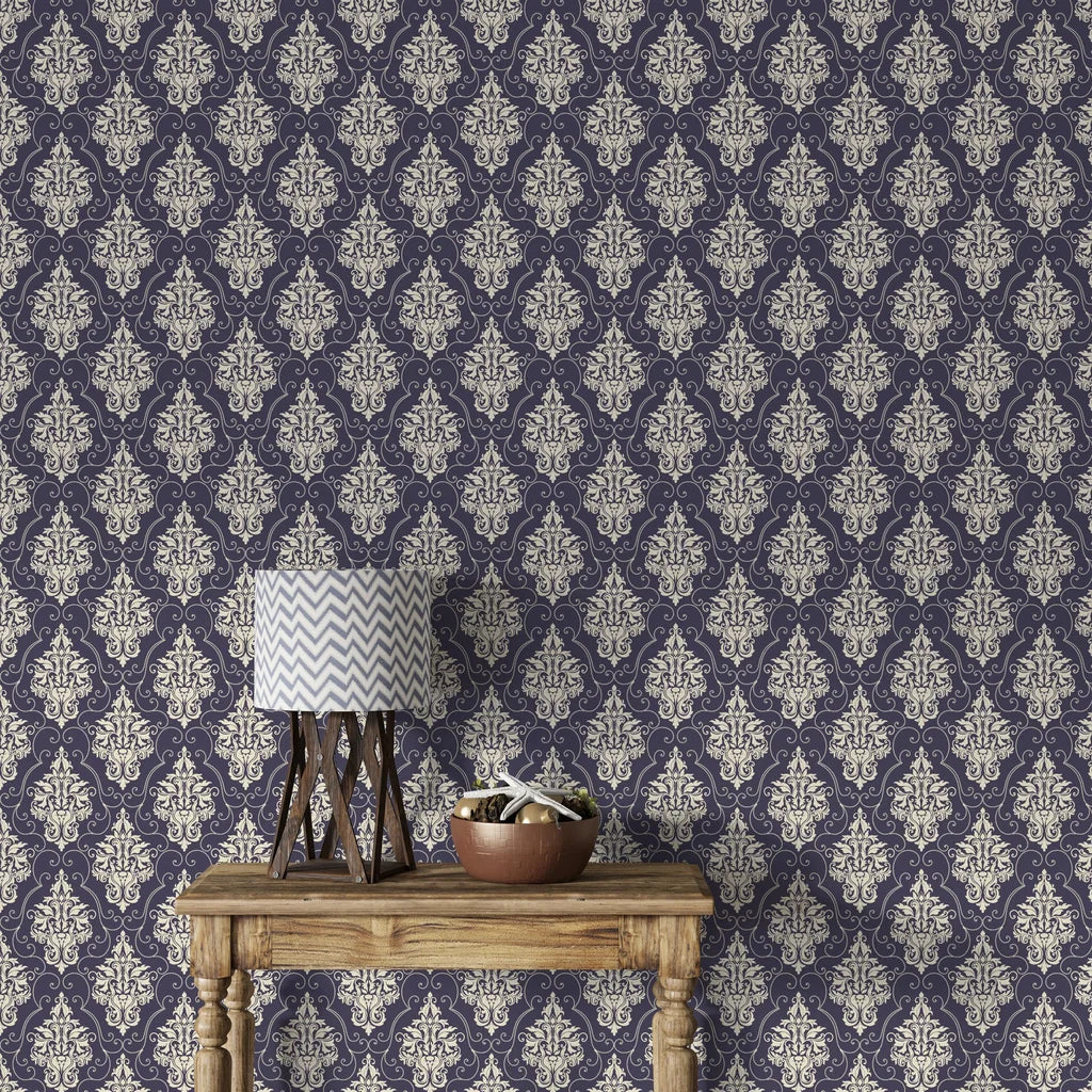Navy and cream Gentlebotan damask wallpaper on living room wall with rustic wood table and chevron lamp