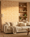 Gilded Brushstroke wallpaper with warm beige geometric pattern on living room accent wall with natural light