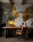 Gilded Thunder gold and charcoal abstract wallpaper adding character to a cozy bedroom