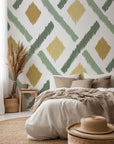 Hand painted geometric wallpaper with soft diamond shapes and angled brush strokes in sage green, olive, and warm ochre on a white background.