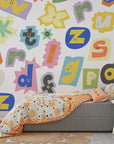 Multicolored collage of magazine letter cutouts arranged in a chaotic ransom note pattern on removable wallpaper - Happy Chaos