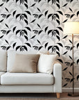 Abstract botanical wallpaper with flowing black leaves and fine line drawn foliage on a warm ivory background.