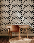 Abstract botanical wallpaper with flowing black leaves and fine line drawn foliage on a warm ivory background.
