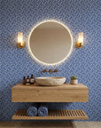 Blue and white Indigo Labyrinth geometric wallpaper in modern bathroom with floating vanity and brass fixtures