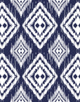 Navy blue ikat style wallpaper with repeating white diamond motifs and textured hand painted edges.