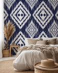 Navy blue ikat style wallpaper with repeating white diamond motifs and textured hand painted edges.