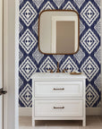 Navy blue ikat style wallpaper with repeating white diamond motifs and textured hand painted edges.