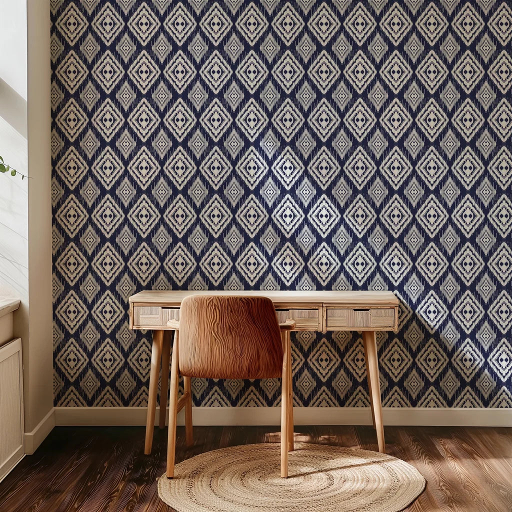 Textured, hand-painted edges frame a navy blue wallpaper design featuring repetitive white diamond motifs in the ikat style