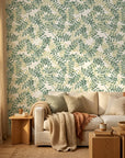 Jade and Citron botanical leaf wallpaper on living room accent wall with beige sofa and natural wood furniture