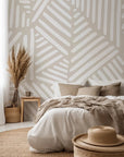 Hand-sketched white linear brush strokes form repeating angular shapes across the neutral beige wallpaper