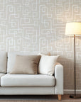 Neutral beige wallpaper with abstract hand drawn white line rectangles arranged in an organic geometric pattern.