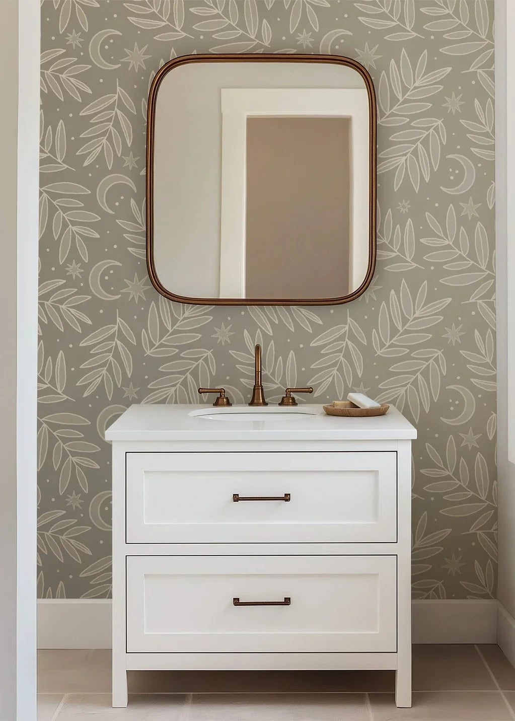 A tender celestial nature-themed wallpaper print featuring finely drawn foliage, tiny stars, and crescent moon shapes over a comforting taupe ground color