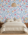 Blue and coral Matisse Reverie floral wallpaper on bedroom accent wall with woven pendant light