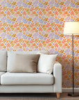 Against a background of warm cream, this abstract botanical wallpaper features playful, hand-painted shapes (leaves and flowers) utilizing a palette of peach, lavender, soft coral, and ochre