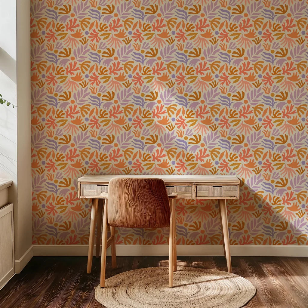 A botanical wallpaper featuring hand-painted abstract leaf and flower designs in peach, ochre, lavender, and soft coral, contrasted with a warm cream base color.